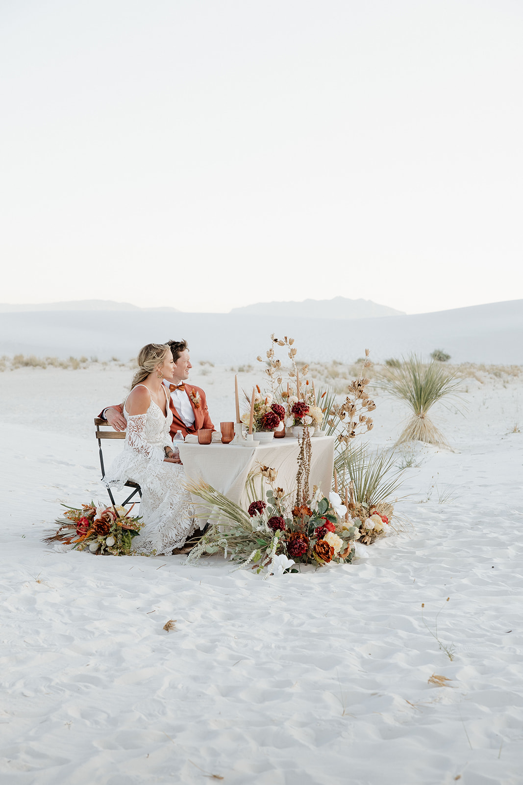 stunning bride and groom pose together with the dunes in background after their dreamy White Sands elopement day