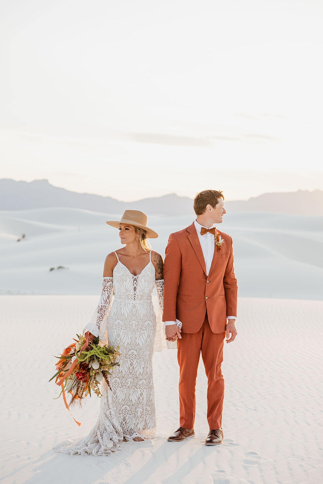 stunning bride and groom pose together with the dunes in background after their dreamy White Sands elopement day