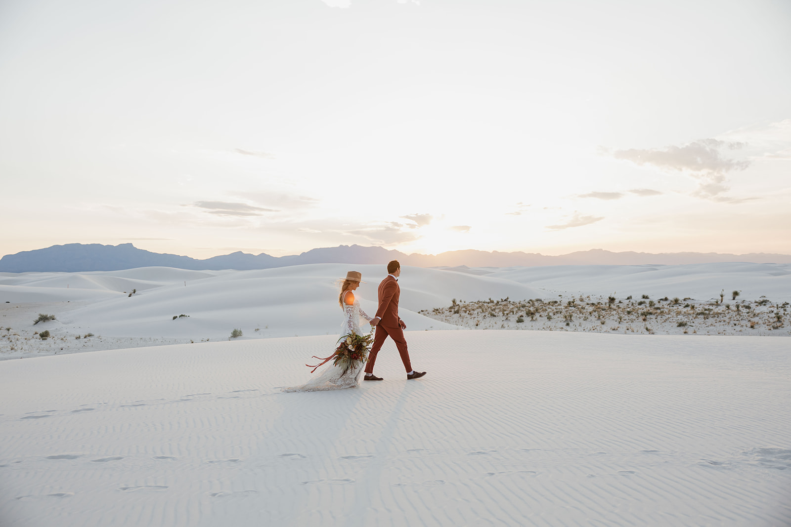 stunning bride and groom pose together with the dunes in background after their dreamy White Sands elopement day