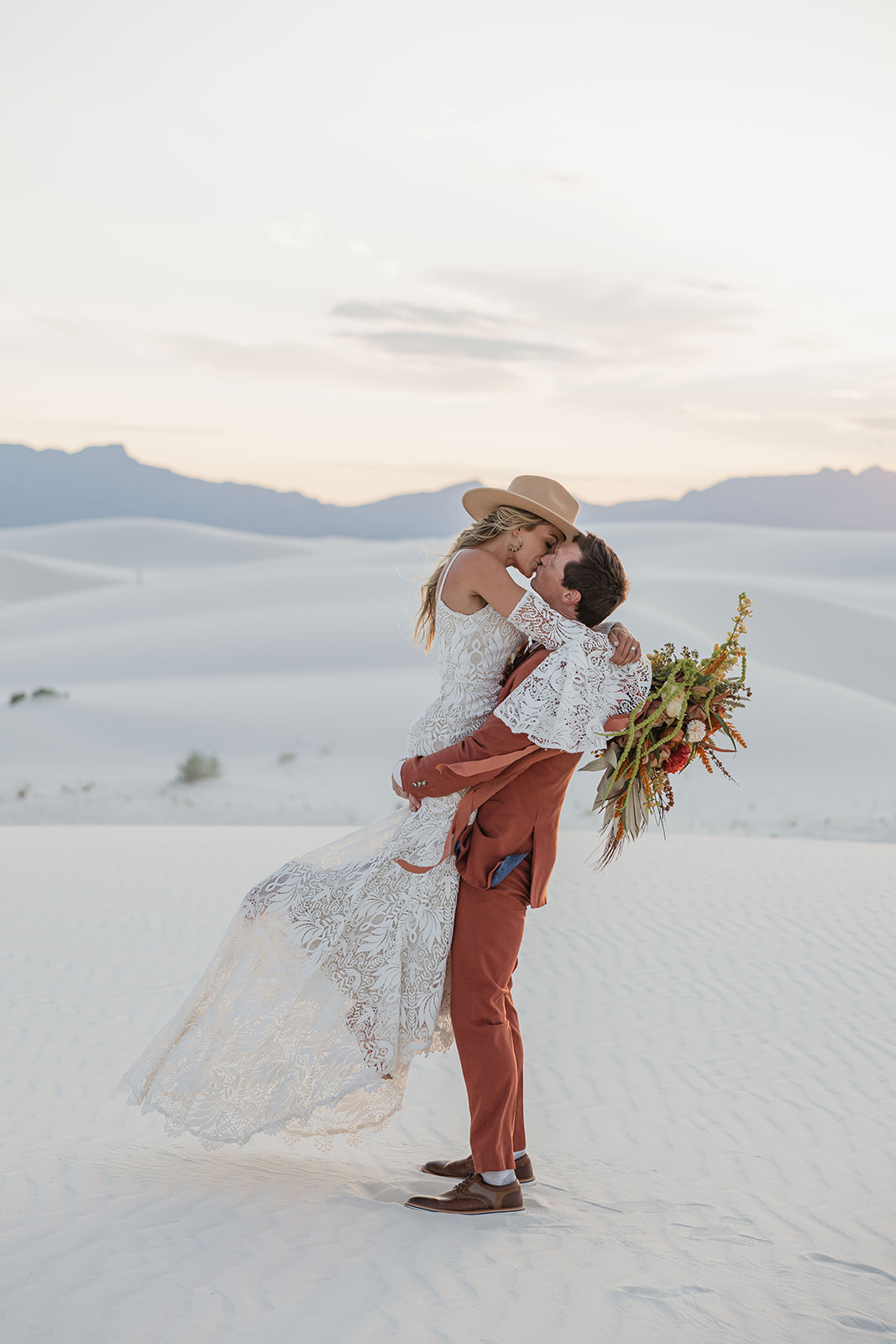 stunning bride and groom pose together with the dunes in background after their dreamy White Sands elopement day