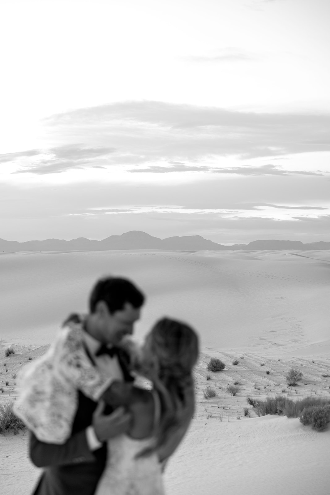 stunning bride and groom pose together with the dunes in background after their dreamy White Sands elopement day