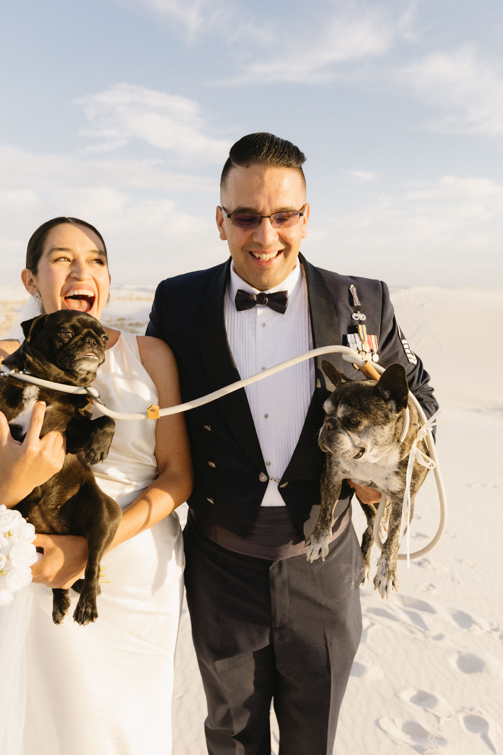 beautiful bride and groom pose together with their dogs after their dreamy elopement