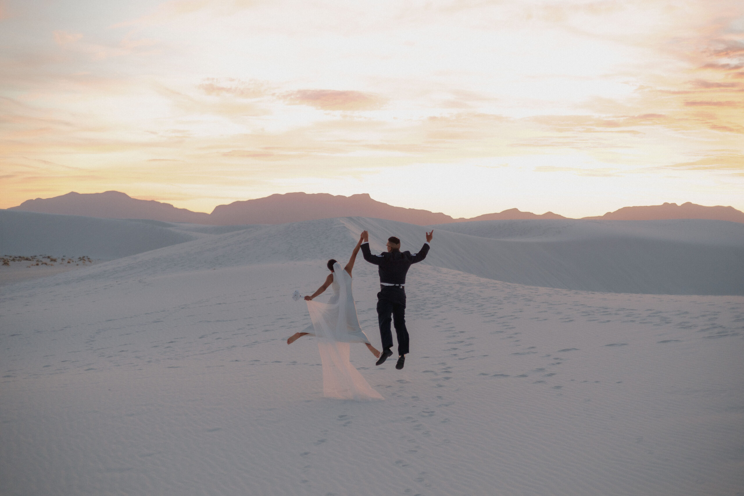 stunning bride and groom pose together with the dunes in background after their dreamy White Sands elopement day