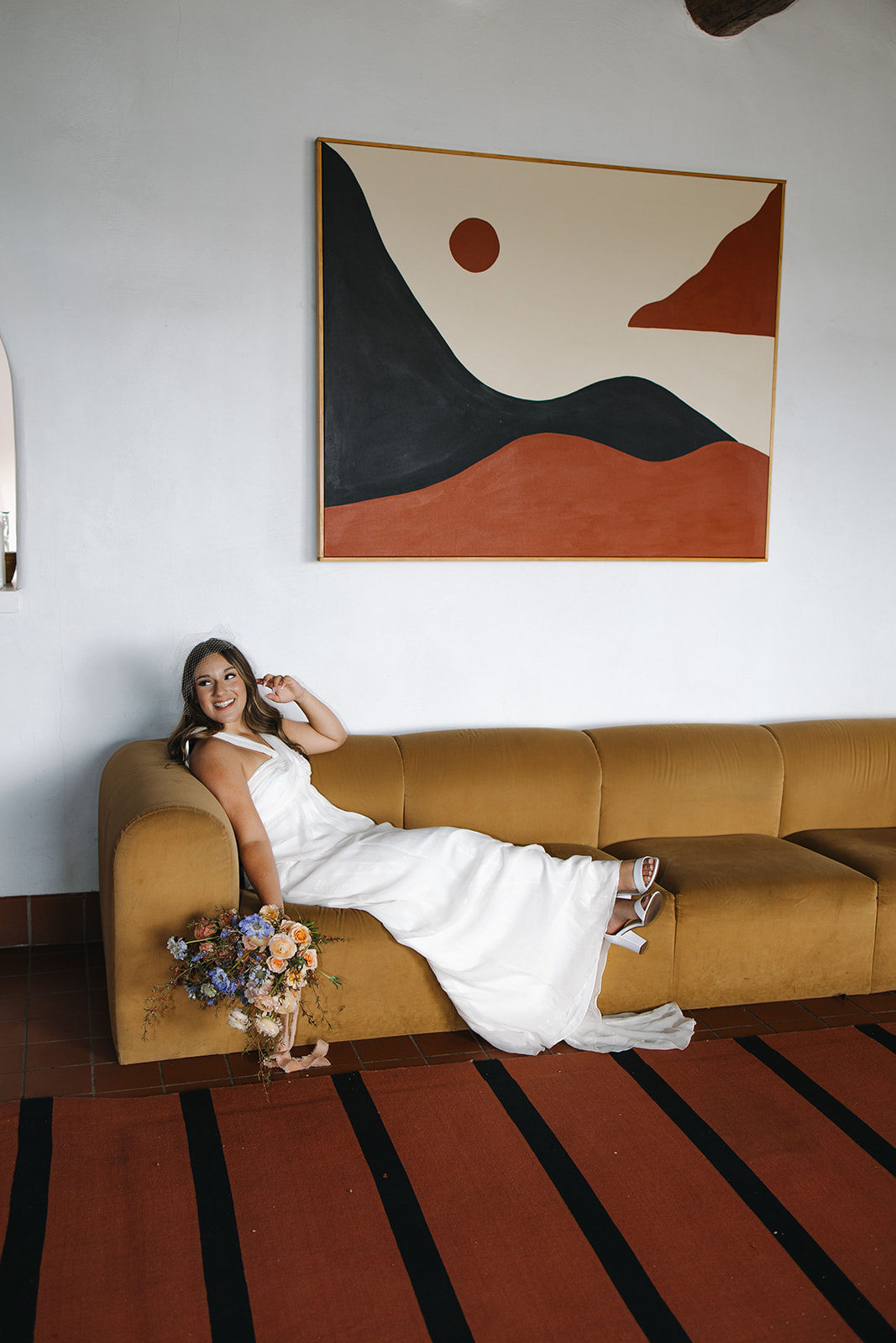 bride poses on the couch after her dreamy wedding day