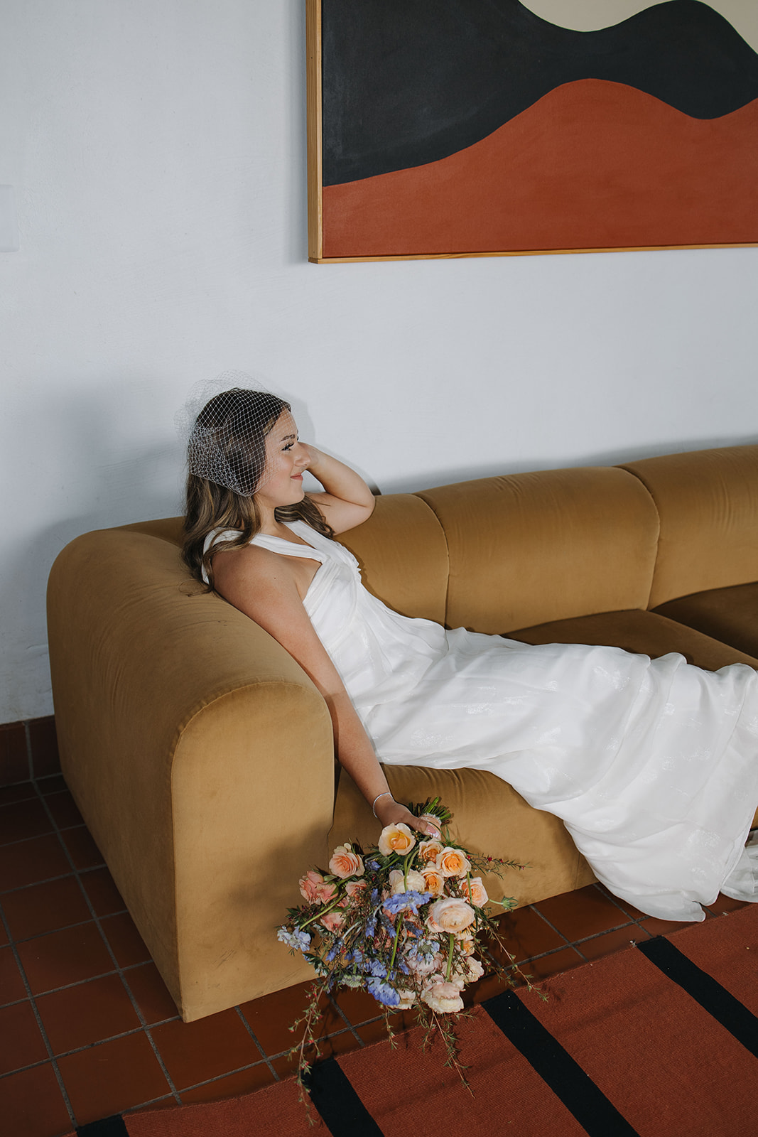 bride poses on the couch after her dreamy wedding day