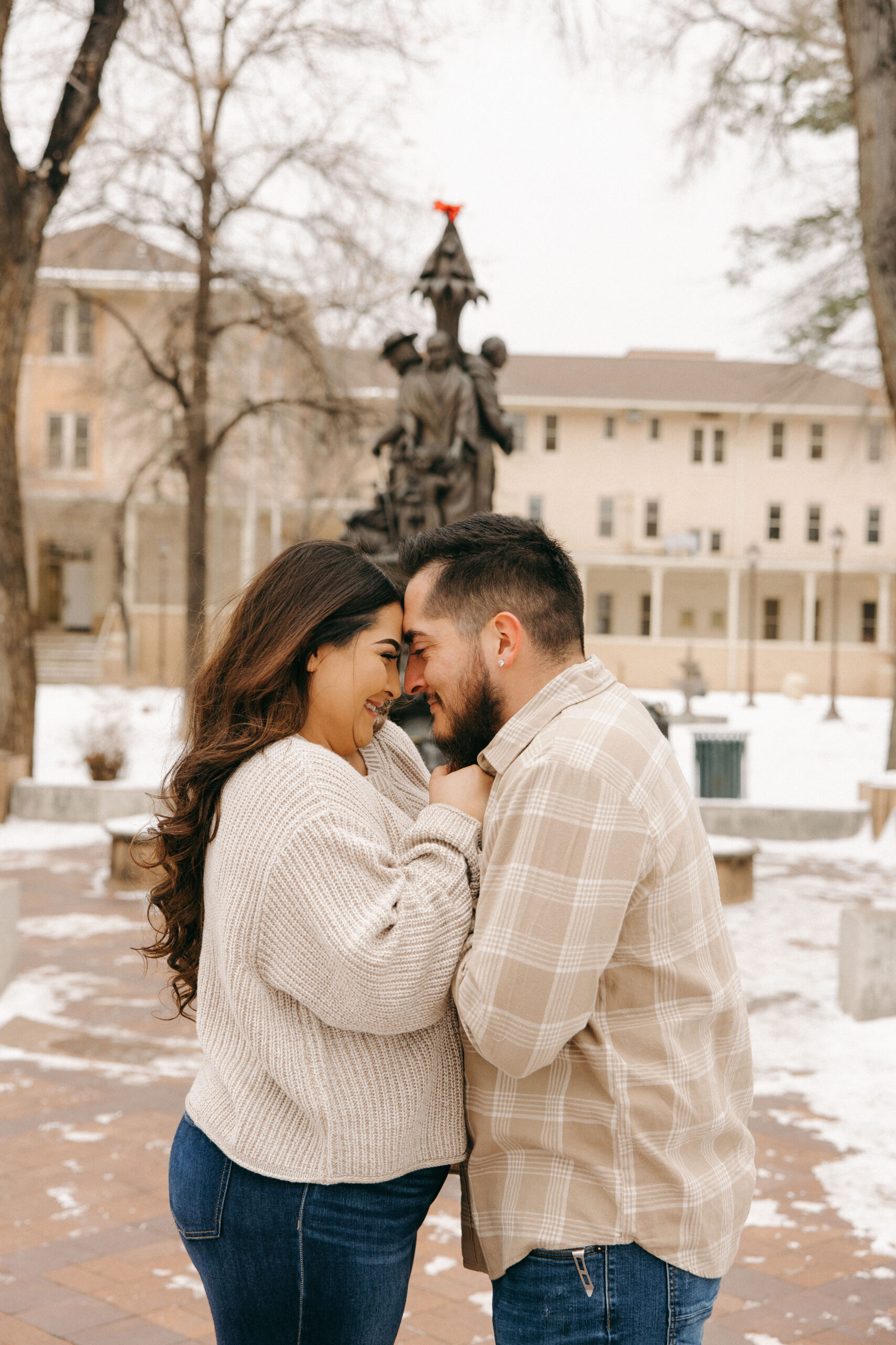 beautiful couple pose together during their winter city engagement photo session